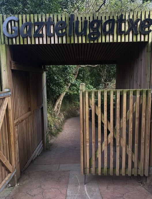 Timber gateway on the path signed Gaztelugatxe at the start of the walk