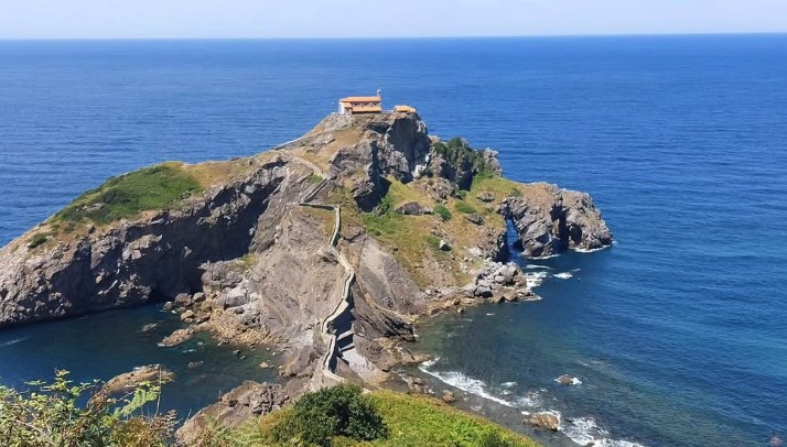 Aerial view of San Juan de Gaztelugatxe surrounded by deep blue water