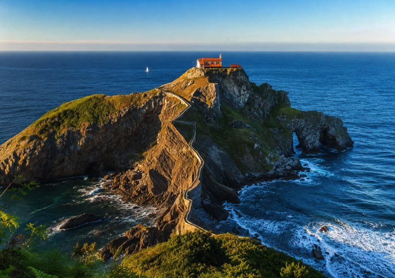 San Juan de Gaztelugatxe at golden hour, the stone staircase winding up to the hermitage